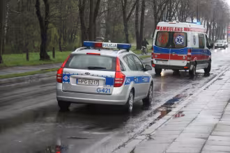 Polizeifahrzeug und Rettungswagen fahren auf nasser Stra&szlig;e