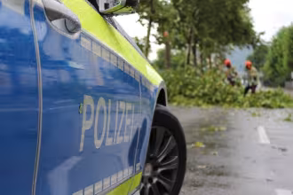 Polizeifahrzeug steht am Stra&szlig;enrand im Gr&uuml;nen